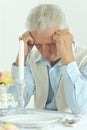 Portrait of sad senior man sitting at table Royalty Free Stock Photo