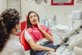 Close-up portrait of a sad young girl with a painful tooth, a doctor in office chairs, an isolated dentist office