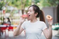 Close up of portrait of a satisfied Asian girl enjoy eating donuts in front of her house.