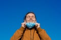 Close up portrait of a satisfied man with eyes closed taking off his medical mask.