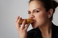 Close up portrait of a satisfied pretty young girl eating donut isolated over white background. Royalty Free Stock Photo