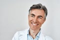 Close up portrait of senior cheerful male doctor smiling while posing against grey background in studio. Headshot Royalty Free Stock Photo