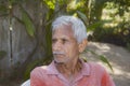 Close-up portrait of Senior citizen Indian man sitting on a chair in the evening sad thinking something Royalty Free Stock Photo