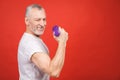 Close-up portrait Of A Senior Man Exercising with dumbbells against red Background Royalty Free Stock Photo