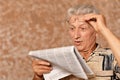 Close-up portrait of senior man reading newspaper on a beige background Royalty Free Stock Photo