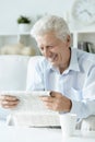 Portrait of senior man reading newspaper at home Royalty Free Stock Photo