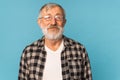 close-up portrait of a senior man thinking about something on blue background Royalty Free Stock Photo