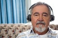 Close up portrait of senior man wearing headphones in nursing home Royalty Free Stock Photo