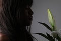 Close-up portrait of sensual woman holding iris flower. Isolated on grey wall. Royalty Free Stock Photo