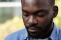 Close up portrait of serious African American man with closed eyes. Handsome young calm man in blue denim shirt on the Royalty Free Stock Photo