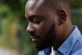 Close up portrait of serious African American man with closed eyes. Handsome young calm man in blue denim shirt on the Royalty Free Stock Photo