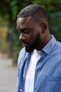 Close up portrait of serious African American man with closed eyes. Handsome young calm man in blue denim shirt on the Royalty Free Stock Photo