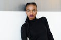 Close-up portrait of a serious african or black american woman looking at camera standing over white background Royalty Free Stock Photo