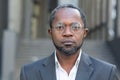 Close up portrait of serious businessman, afro american man in business suit and glasses looking at camera thinking Royalty Free Stock Photo