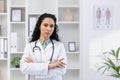 Close-up portrait of serious and confident hispanic female doctor, woman looking at camera with crossed arms Royalty Free Stock Photo