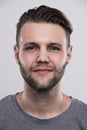 Close up portrait of serious gloomy bearded man with stylish hairstyle posing against white background Royalty Free Stock Photo