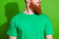 Close up portrait of serious handsome guy with long red beard wear stylish t-shirt look empty space isolated on green Royalty Free Stock Photo