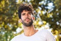 Close up serious handsome man with beard outside in nature