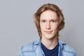 Close up portrait of serious handsome man with trendy hairdo, dark eyes, wears denim jacket, looks directly into camera, isolated Royalty Free Stock Photo