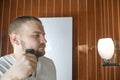 Close up portrait of a serious man shaving beard with an electric razor Royalty Free Stock Photo