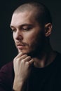 Close-up portrait of a serious young man looking away on a gray background. bald with a beard Royalty Free Stock Photo