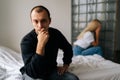 Close-up portrait of serious young man pensive looking at camera not talking after dispute with sad wife sitting apart Royalty Free Stock Photo