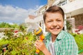 Smiling boy watering garden using hand sprinkler Royalty Free Stock Photo