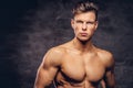 Close-up portrait of a shirtless young man model with a muscular body and stylish haircut posing at a studio Royalty Free Stock Photo