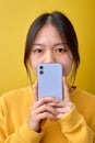 Close-up portrait of shocked asian female holding smartphone in hands, emotions concept Royalty Free Stock Photo