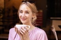 Close-up portrait shot of happy young woman drinking coffee at the cafe Royalty Free Stock Photo