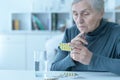 Portrait of sick senior woman taking medicine