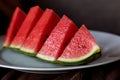 A close up portrait of a sliced up quarter of a watermelon. The fruit is red in the middle with black seeds and has a green Royalty Free Stock Photo