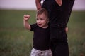 Close-up portrait of small boy looking curiously ahead while being held securely by parents hand Royalty Free Stock Photo