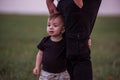 Close-up portrait of small boy looking curiously ahead while being held securely by parents hand Royalty Free Stock Photo