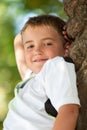 Portrait of cute boy resting in tree. Royalty Free Stock Photo