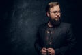 Close-up Portrait of a smart bearded man wearing a black jacket standing in a dark studio