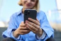 Close up portrait of smartphone in hands of young woman, who sits and rests on stairs outdoors Royalty Free Stock Photo