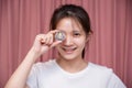 close up Portrait of a smiling Asian woman wear white shirt and holding Golden Ethereum ETH with Cryptocurrency hand picked and