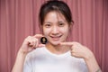 close up Portrait of a smiling Asian woman she is winning wear white shirt and holding Golden Ethereum ETH with Cryptocurrency and