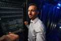 Bearded man technician working with it equipments in server farm