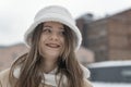 Close-up portrait of smiling girl in fashionable white fur panama in winter outdoors. Woman in trendy headdress Royalty Free Stock Photo