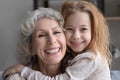 Portrait of happy old grandmother and little granddaughter hugging Royalty Free Stock Photo