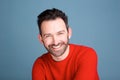 Smiling man with beard posing against blue background