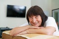 Close up portrait of smiling mature woman sitting on cozy sofa by Royalty Free Stock Photo