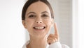 Portrait of smiling young woman apply facial cream Royalty Free Stock Photo