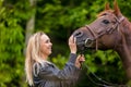 Close-up of smiling woman feeding her arabian horse with snacks Royalty Free Stock Photo