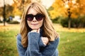 Close-up portrait of smiling woman relaxing in the park and enjoying fall weather Royalty Free Stock Photo