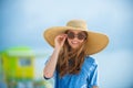 Close-up portrait of smiling woman by the sea. Happy woman in sunglasses and straw hat standing at the seaside.