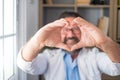 Close up portrait of smiling young caucasian male nurse or GP in white medical uniform show heart love hand gesture. Happy man Royalty Free Stock Photo