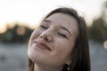 Close-up portrait of smiling young girl. Happy sincere smile. Contented young woman on the street